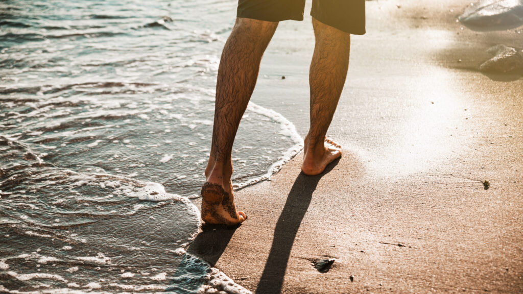 homem caminhando na praia