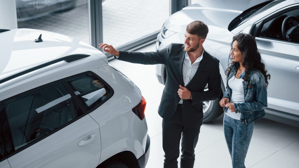 mulher comprando carro em concessionária