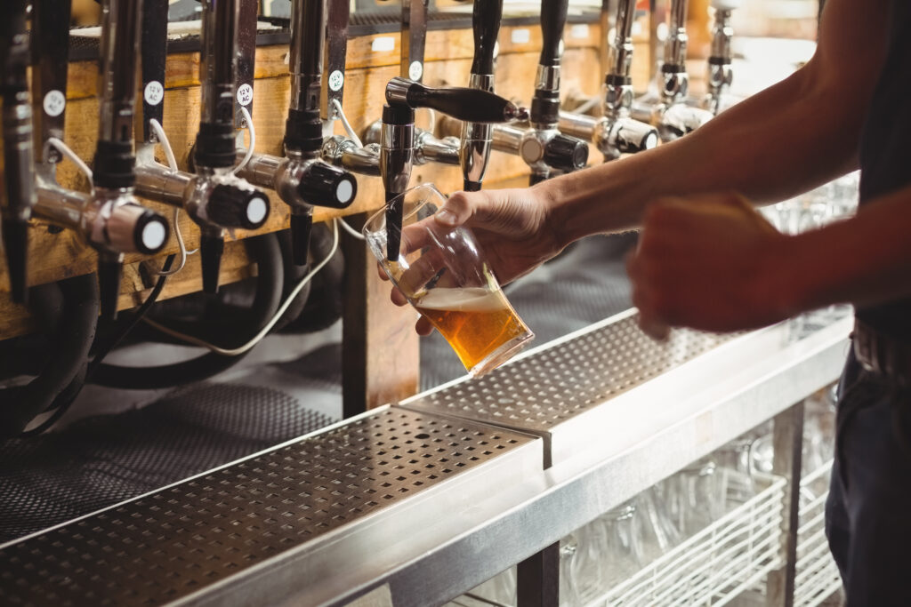 cerveja sendo servida na torneira de uma fábrica