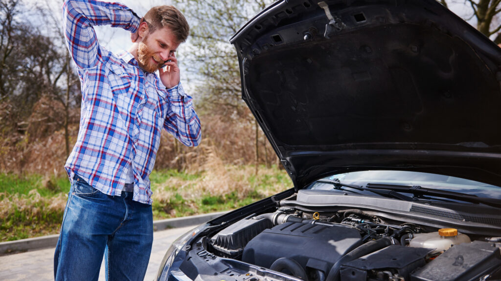 homem com problemas no motor do carro