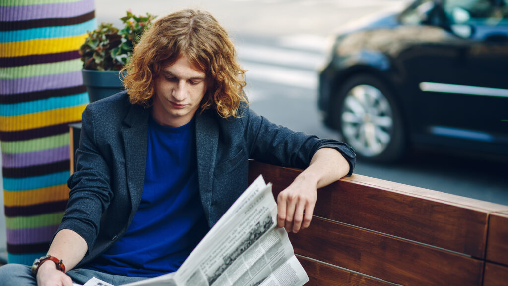 homem lendo jornal imprensa carro