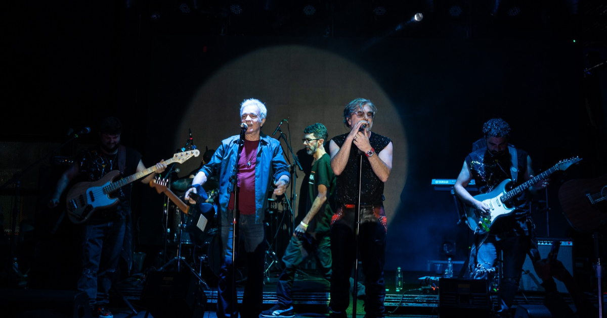 artistas cantando e tocando no palco