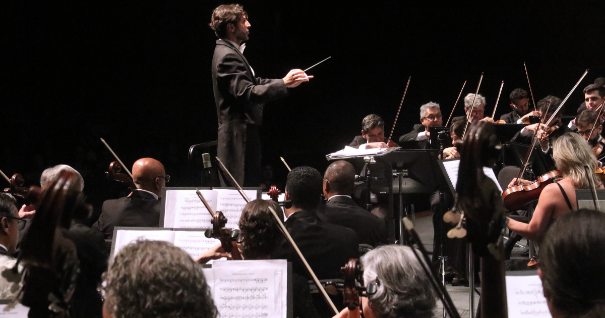 maestro conduzindo orquestra sinfônica de minas gerais