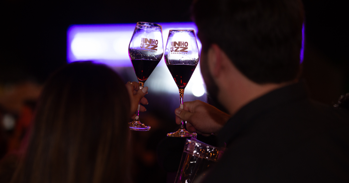 pessoas segurando taças de vinho