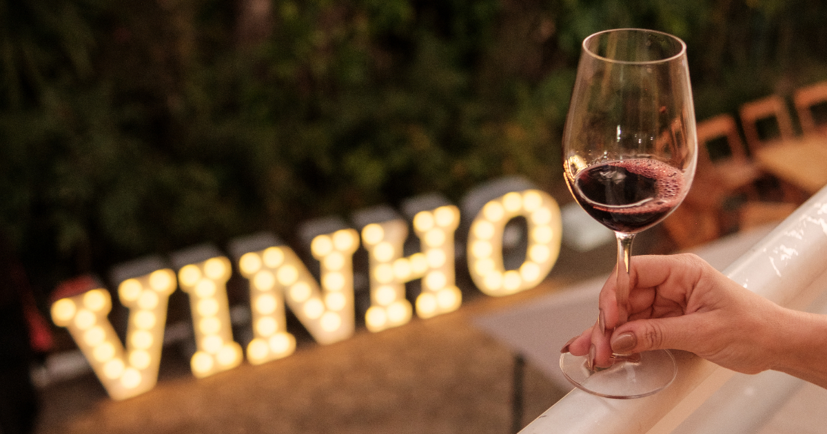 pessoa segurando uma taça de vinho tinto