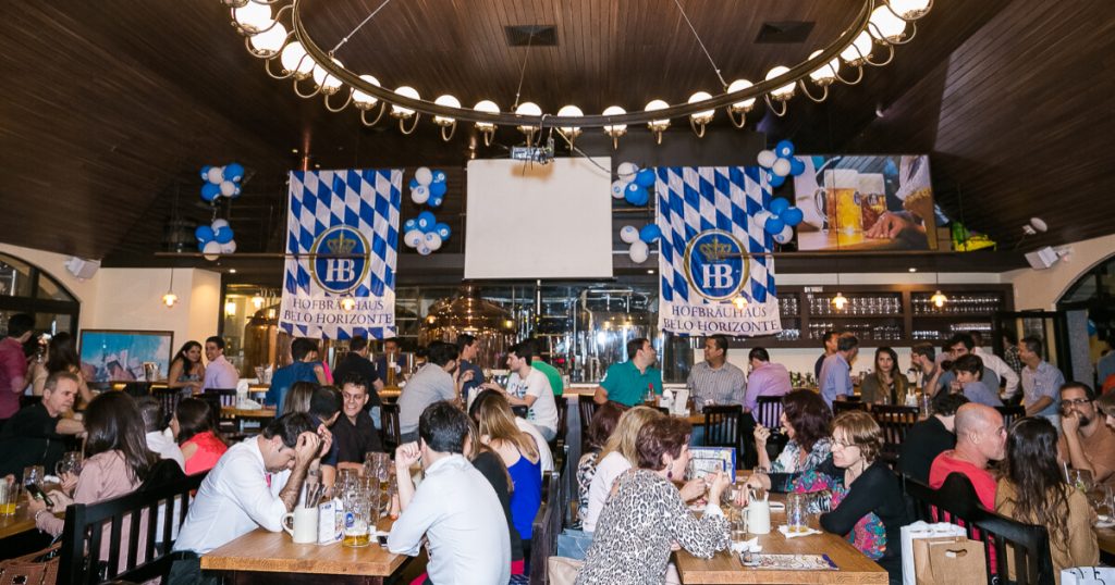 clientes sentados à mesa no ambiente interno da cervejaria Hofbräuhaus