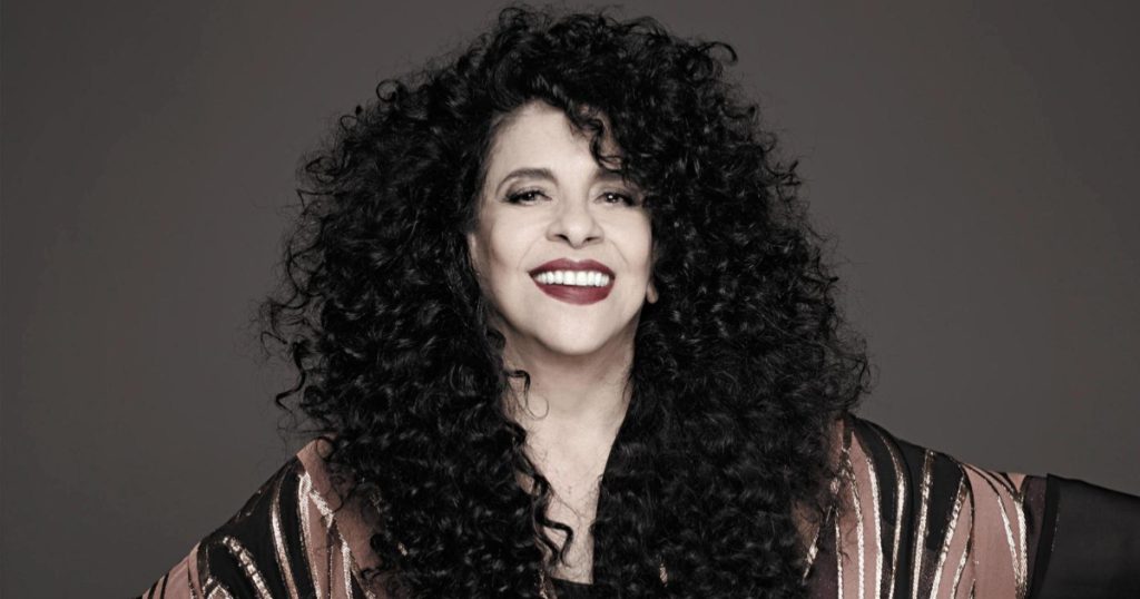 gal costa de cabelos soltos e volumosos e sorrindo