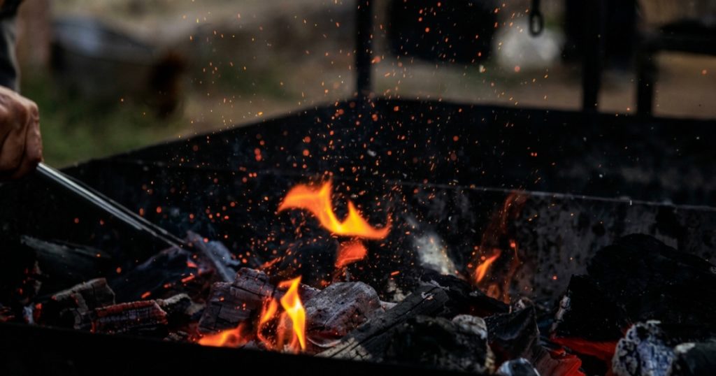 pessoa atiçando fogo na brasa