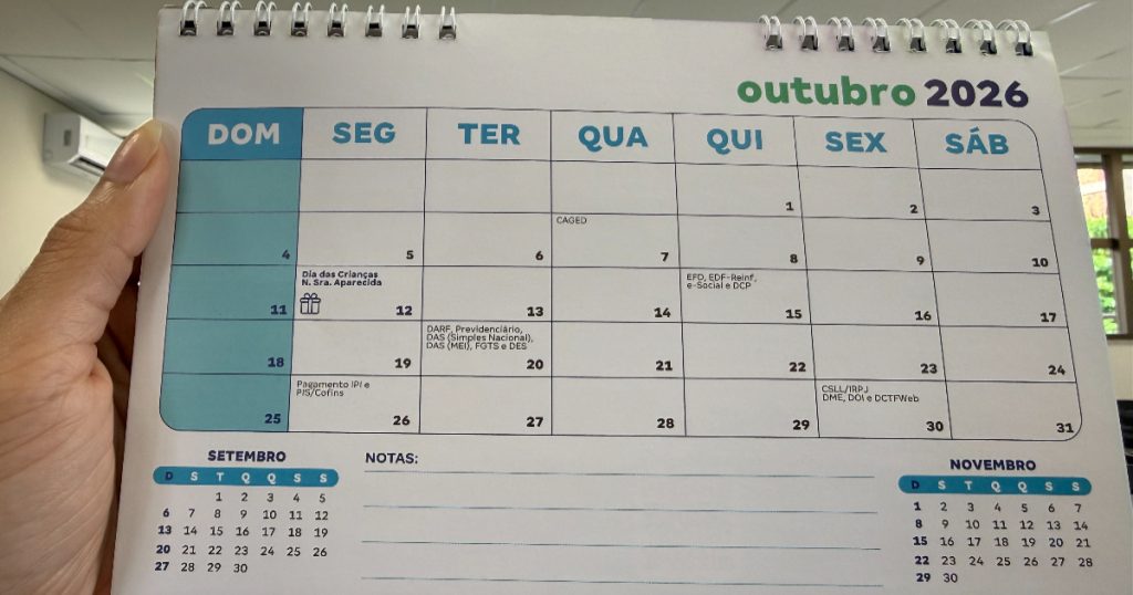 pessoa segurando um calendário do mês de outubro de 2026