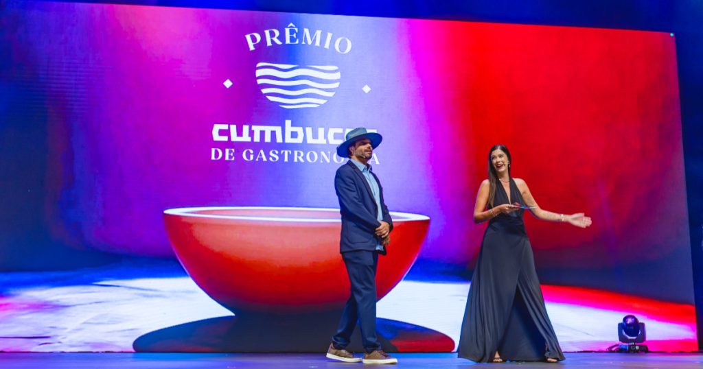 apresentadores no palco do prêmio cumbucca de gastronomia