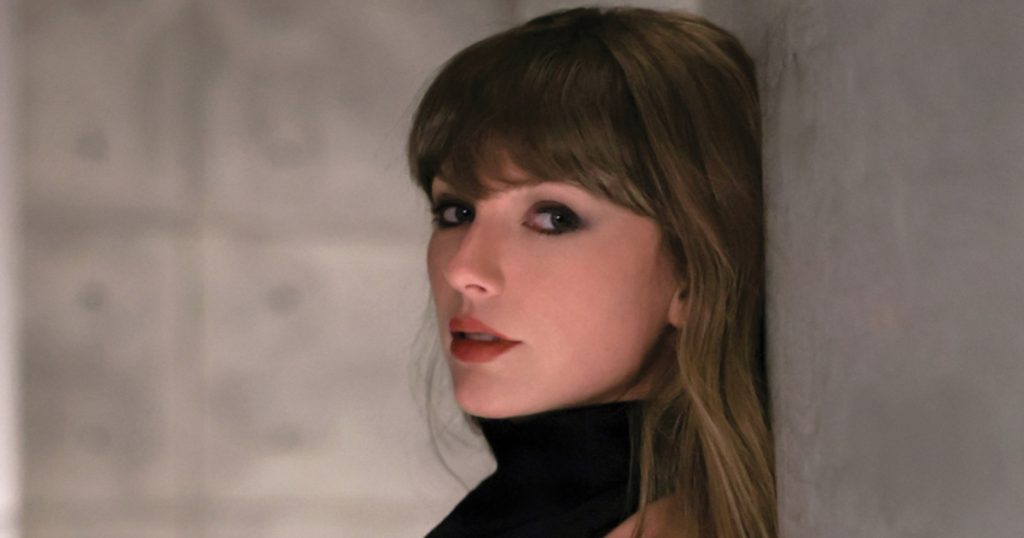 taylor swift posando encostada em uma parede